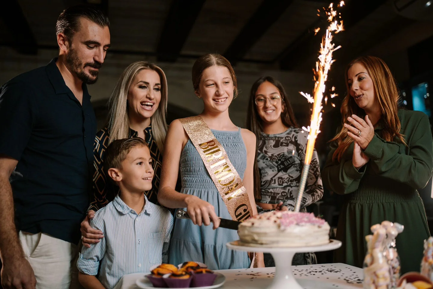 Family and friends celebrating together around a birthday cake